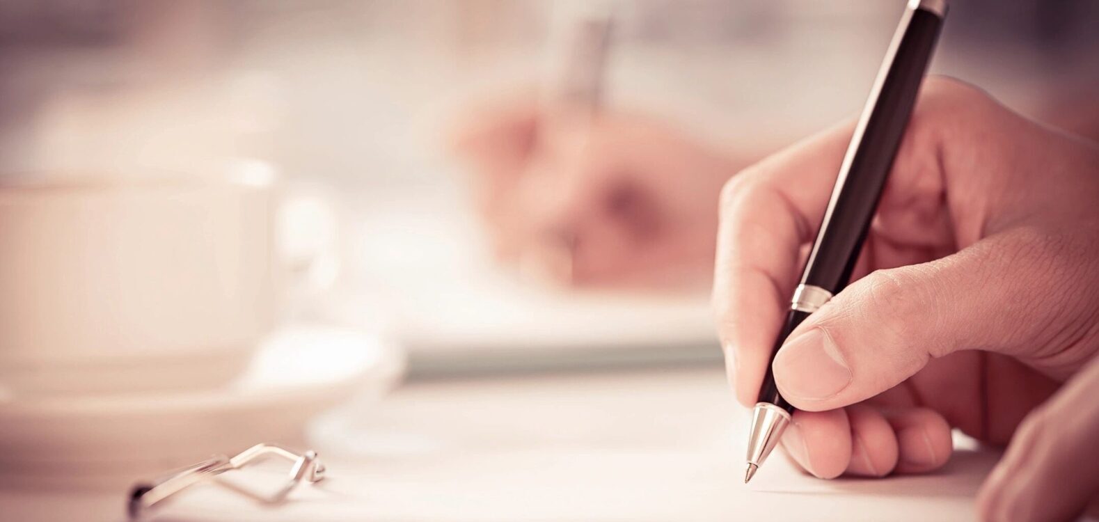 A person signing a piece of paper