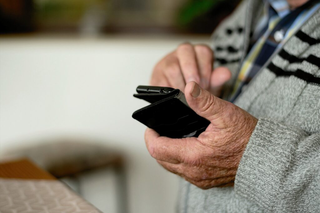 A senior citizen holding a mobile phone